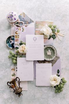 the wedding stationery is laid out on top of each other with flowers and plates