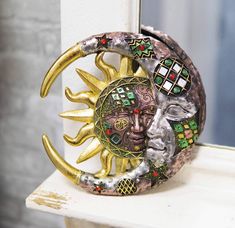 a decorative sun and moon decoration on a window sill