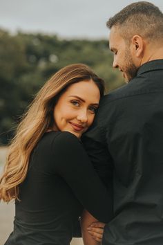 a man and woman embracing each other on the beach