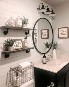 a white bathroom with black and white decor on the wall, shelves above the toilet