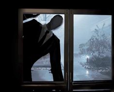 a person standing in front of a window on a snowy day