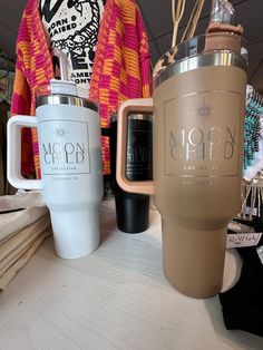 two coffee mugs sitting next to each other on a table