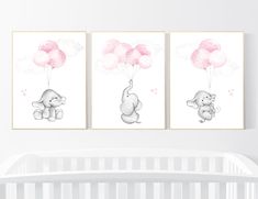 two elephants with pink balloons are hanging on the wall next to a crib in a baby's room