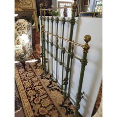 a green metal bed frame sitting on top of a rug