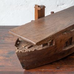 an old wooden boat is sitting on the floor