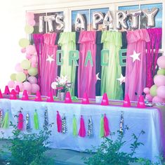 there is a party table with balloons and streamers on the wall, along with other decorations