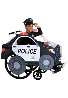 a boy in a police car costume is riding on a small toy bike with wheels