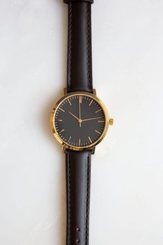 This is Unisex Watch. This 36mm watch is recommended for men that prefer smaller watches. For women, this is a classic medium size case. ✦ Case Size: 36mm ✦ Case Material: Gold Tone Stainless Steel ✦ Japanese Quartz Movement ✦ Mineral Glass ✦ Analog Display ✦ Strap: Dark Brown (Almost Black) Genuine Leather ✦ Strap Width: 16mm ✦ 3 ATM Water Resistance (protected from splashes such as hand washing, rain but must not be worn while bathing, swimming or diving) Dark Brown Leather Minimalist Watch, W Minimalist Gold Watch With Leather Strap, Gold Minimalist Watches, Brown Minimalist Watches For Business, Brown Minimalist Watch For Business, Minimalist Brown Business Watches, Minimalist Leather Strap Watch For Everyday, Minimalist Quartz Watches For Work, Minimalist Leather Strap Watch, Minimalist Watch Accessories With Subdials For Everyday Use