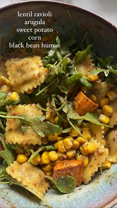 a bowl filled with pasta and vegetables on top of a table