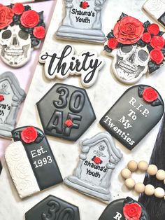 decorated cookies are arranged on a table with red roses and black lettering that says thirty