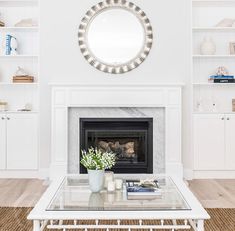 a living room with white furniture and a fireplace