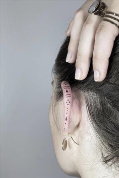 a woman with her hair tied back to her head, holding the top part of her head