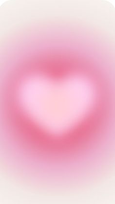 a blurry image of a pink heart in the middle of it's frame