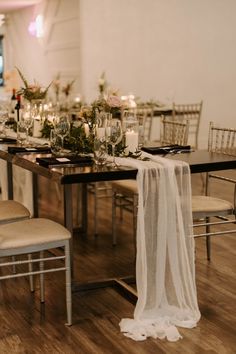 the table is set with candles, flowers and greenery for an elegant wedding reception