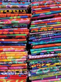 many different colored fabrics are stacked on top of each other in the same pattern and color