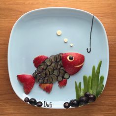 a plate that has some food on it with fish and plants in the bowl next to it