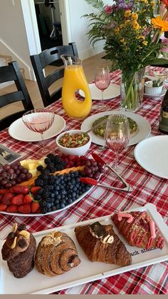 a table topped with plates and bowls filled with food next to a vase full of flowers