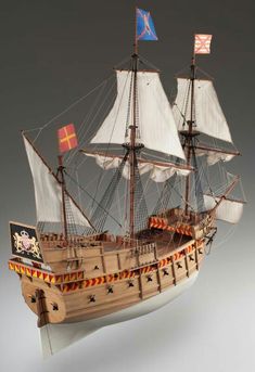 a wooden pirate ship with two flags on it's mast