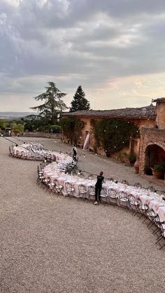 an outdoor dining area with tables and chairs set up in the shape of a curve