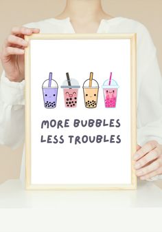 a woman holding up a framed poster with three drinks on it that says more bubbles less troubles