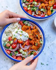 two bowls filled with chicken, rice and veggies