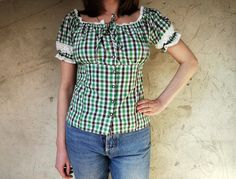 "Vintage gingham pattern dirndl blouse, from the 90s Women's folk check pattern blouse in green, brown and white with elastic neckline and puffy sleeves. Beautiful cotton white lace detail on the neckline and sleeves. Closes with buttons in the front, adjusted with a tie at the back. Material - 45% cotton, 55% polyester Size - M Approximate Measurements (taken with top lying flat, double \"armpit to armpit\" and \"waist\" measurements): Armpit to Armpit (double that) - 17.7 inches / 45 cm Waist Fitted Cotton Peasant Top In Cottagecore Style, Fitted Cotton Peasant Top Cottagecore Style, Fitted Peasant Blouse For Fall, Plaid Fitted Blouse With Puff Sleeves, Fitted Plaid Puff Sleeve Blouse, Fitted Plaid Blouse With Puff Sleeves, Vintage Fitted Peasant Top With Puff Sleeves, Fitted Gingham Blouse With Puff Sleeves, Fitted Vintage Peasant Top For Summer