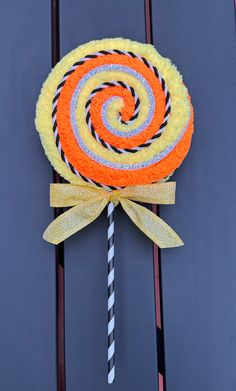 an orange and white lollipop on a stick