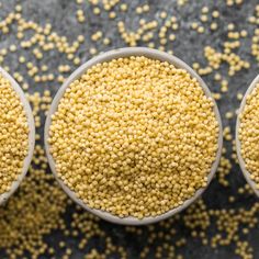 three bowls filled with yellow seed on top of a table