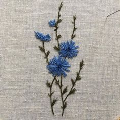 some blue flowers are on a white cloth