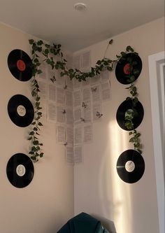 there are many records on the wall with plants growing out of them in this room