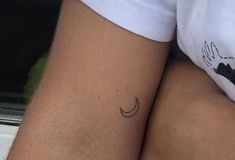 two people with small tattoos on their legs, one is holding the other's arm