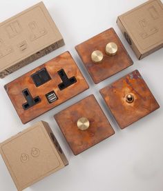 four different types of electrical switches and sockets in cardboard boxes on a white surface with black knobs