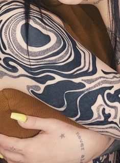 a woman with tattoos on her arm holding a cell phone