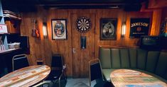 the darts are on the wall behind the booth and tables in the room with darts