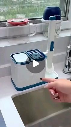 a person is pointing at the sink in front of a faucet and soap dispenser