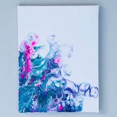 an abstract painting on white paper with blue, pink and green paint splatters