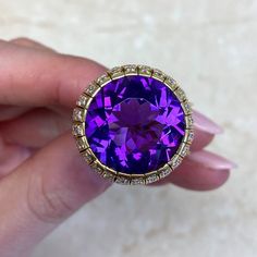 This item has just been reserved by another customer. Please contact us to be notified if it becomes available.  This beautiful Amethyst ring has a round-shaped amethyst with a deep purple color. The amethyst ring weighs approx  13.54 carats and is set in high-quality 18k yellow gold. The Amethyst ring design is enhanced with a row of dazzling diamonds carefully placed on the gold setting.  This vintage ring originating from the 1970s exudes a timeless charm and showcases the stunning allure of Luxury Multi-stone Amethyst Ring For Formal Occasions, Luxury Formal Amethyst Gemstones, Luxury Round Amethyst Ring With Gemstone Accents, Luxury Vvs Clarity Amethyst Ring For Formal Occasions, Luxury Hallmarked Amethyst Collectible Ring, Luxury Amethyst Gemstones For Anniversary, Luxury Round Amethyst Gemstones, Formal Multi-stone Amethyst Ring With Round Cut, Formal Purple Amethyst Ring With Vvs Clarity