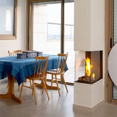 a dining room with a table and chairs next to a fire place in the fireplace