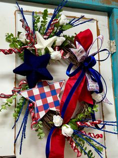 two patriotic wreaths with red, white and blue ribbons on a wooden frame in the shape of a star