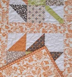 an orange and white quilted wall hanging