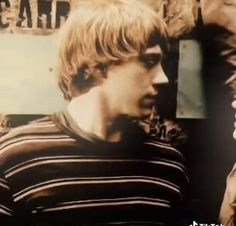 a young man standing in front of a sign