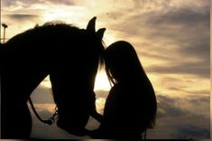 two people standing next to each other with a horse in the foreground and clouds in the background