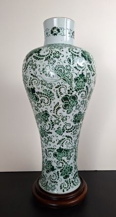 a green and white vase sitting on top of a table