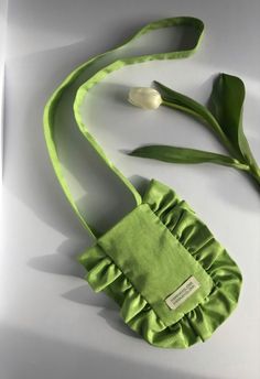 a green purse with a flower on it