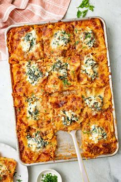 a casserole dish with spinach and cheese on it, next to two plates