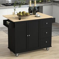 a kitchen island cart with wine bottles and pears on the top, in front of a counter