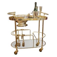 a gold bar cart with drinks on it