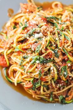 a plate full of spaghetti with sauce and vegetables