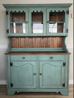 an old blue china cabinet with glass doors