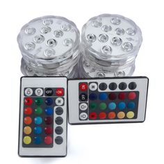 two remote controls sitting next to each other on a white surface with different colored buttons